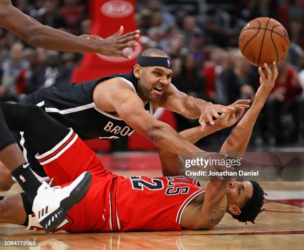 Cameron Payne of the Chicago Bulls passes on his back for an assist under pressure from Jared Dudley of the Brooklyn Nets at the United Center on...