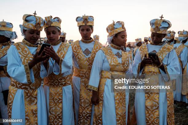 Ethiopian Orthodox christians use smartphones during the annual celebration of Timkat, the Ethiopian Epiphany, in Jan Meda sports ground in Addis...