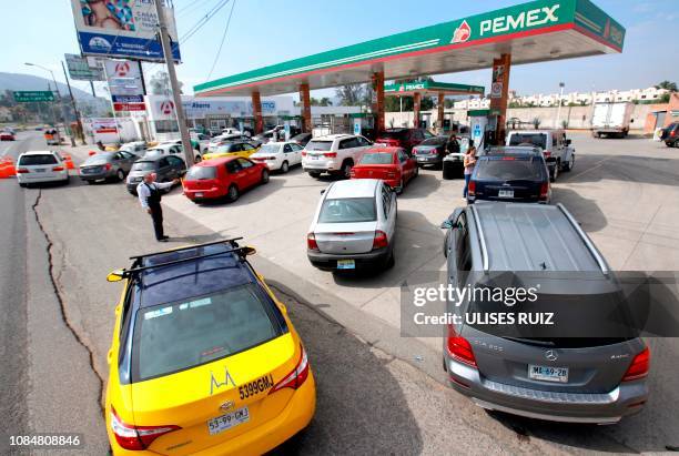 Motorists queue at a Pemex service station in Tlajomulco, Jalisco State, Mexico, on January 18, 2019 as a controversial government crackdown to fight...