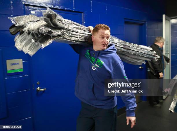 Vancouver Canucks trainer Brian Hamilton carries sticks to the team dressing room before their NHL game against the Buffalo Sabres at Rogers Arena...