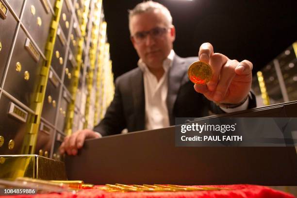 Seamus Fahy, co-founder of Merrion vaults holds a Brittania 1 ounce gold coin at the Merrion vaults in Dublin on January 7, 2019. - In a vault under...