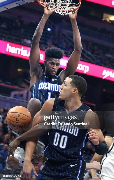 The Orlando Magic's Jonathan Isaac dunks over the top of teammate Aaron Gordon against the Brooklyn Nets at the Amway Center in Orlando, Fla., on...