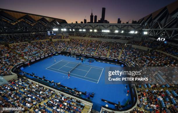 France's Lucas Pouille plays Australia's Alexei Popyrin as the sun sets over the skyline during their men's singles match on day six of the...