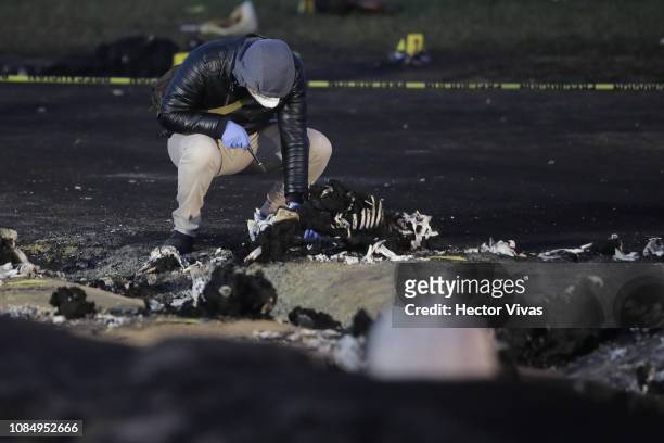 Forensic doctor works with burned bodies after an explosion in a pipeline belonging to Mexican oil company PEMEX on January 19, 2019 in Tlahuelilpan,...