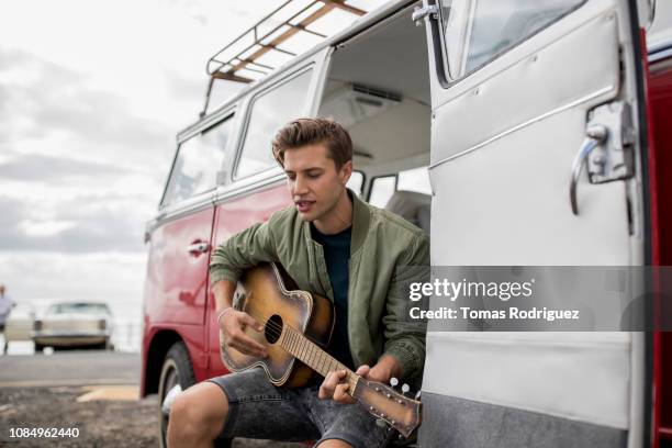 young man playing guitar at a van - car passion stock pictures, royalty-free photos & images