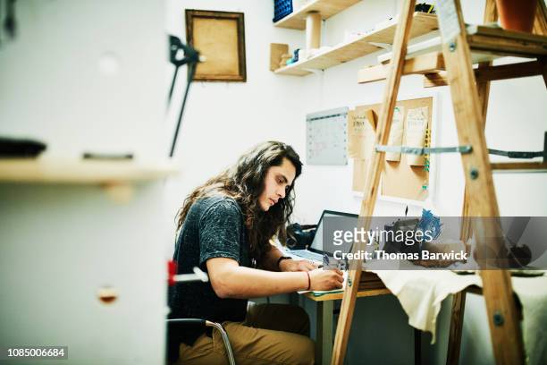 Artist doing paperwork at desk in studio