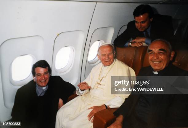 Italian cardinal Roberto Tucci with Pope John Paul II in a plane during one of Pope John Paul II's trips around the world.