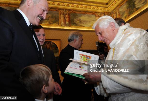 Pope Benedict XVI is handed a children's book by Nikolai, son of Belarus President Alexander Lukashenko- Pope Benedict XVI met Belarus President...