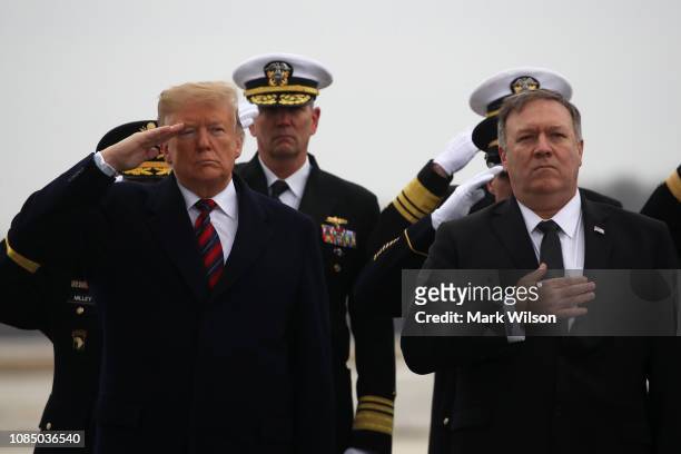 President Donald Trump salutes while joined by Secretary of State Mike Pompeo as a military carry team moves the transfer case containing the remains...