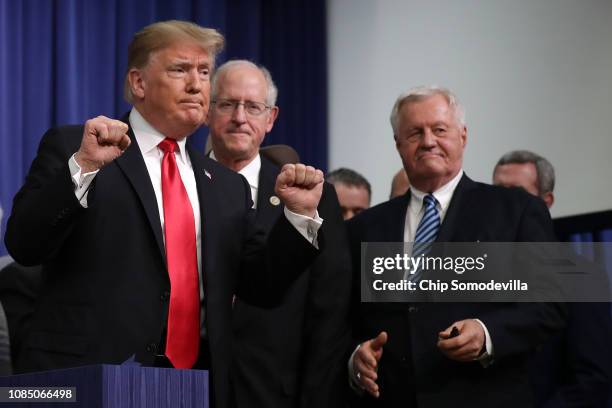 President Donald Trump pumps his fists after signing the the Agriculture Improvement Act during a ceremony with House Agriculture Committee Chairman...