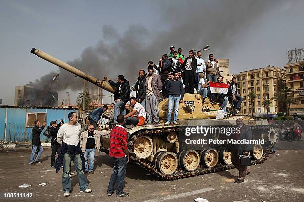 Protestors chant as they stand on an army tank in Tahrir Square on January 29, 2011 in Cairo, Egypt. Tens of thousands of demonstrators have taken to...