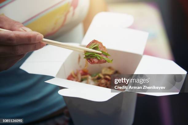 woman eating asian fast food from a cardboard box - chinese food stock pictures, royalty-free photos & images