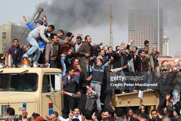 Protestors chant as they ride on an army tank transporter in Tahrir Square on January 29, 2011 in Cairo, Egypt. Tens of thousands of demonstrators...