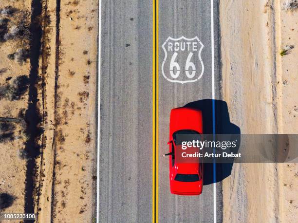 drone view of american car driving in a straight road of the famous route 66. - american muscle car stock-fotos und bilder