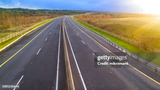 idyllic view of multiple lane highway by sunset time - motorway stock pictures, royalty-free photos & images