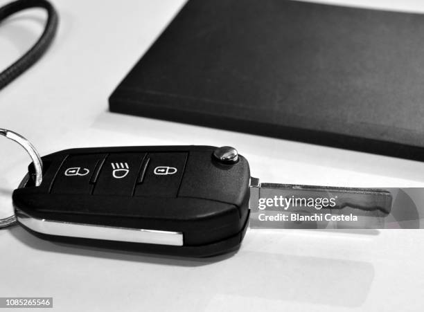 electronic car key and notebook on a table - car keys table stock pictures, royalty-free photos & images