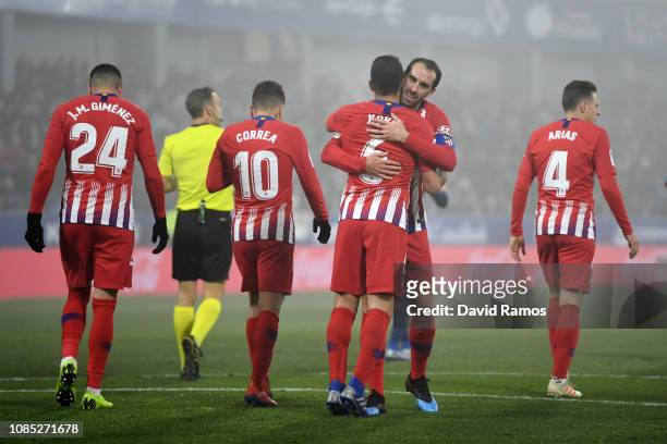 Koke of Atletico Madrid celebrates with teammate Diego Godin after scoring his team's third goal during the La Liga match between SD Huesca and Club...