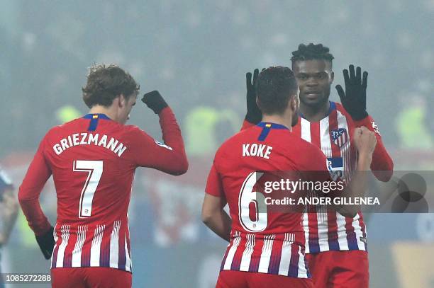 Atletico Madrid's midfielder Koke celebrates with Atletico Madrid's French forward Antoine Griezmann and Atletico Madrid's Ghanaian midfielder Thomas...