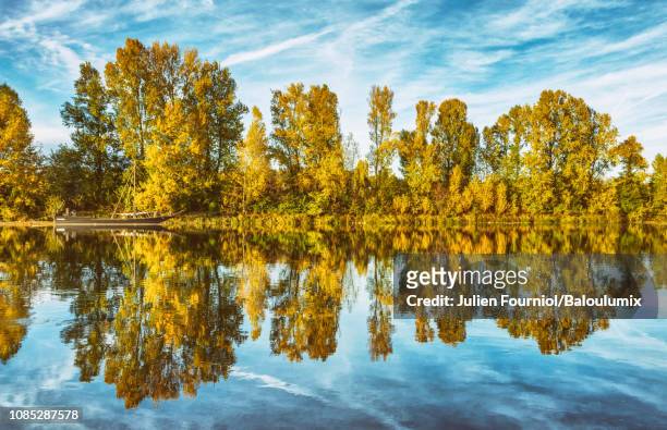 reflections of a boat on the loire, tours, france. - watercourse stock pictures, royalty-free photos & images