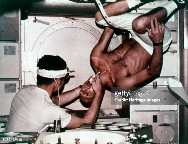 Kerwin examining Conrad on Skylab 2, 1973. Skylab 2 commander Pete Conrad undergoes a dental examination by medical officer Joseph Kerwin in zero...