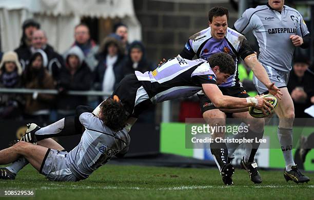 Dave Ewers of Exeter scores a try as Joe Cobden of Leicester holds on to his legs during the LV Anglo Welsh Cup match between Exeter Chiefs and...