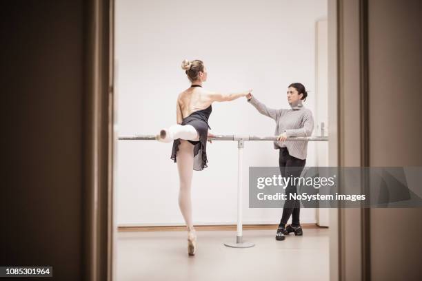 female ballet dancer practicing with instructor in ballet studio. - barre class stock pictures, royalty-free photos & images