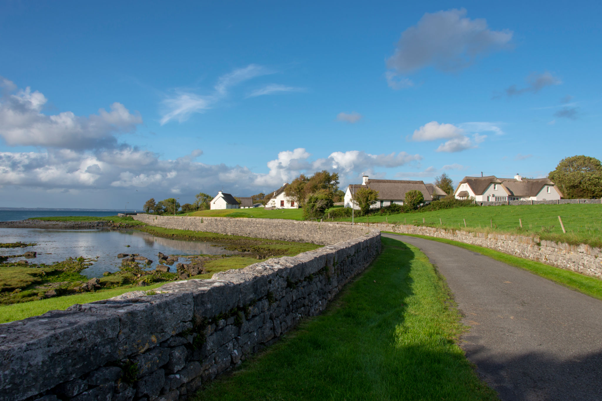 Thatched white cottages along the shore Thatched white cottages along the shore