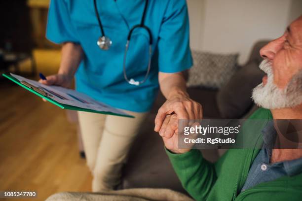 man holding nurse by the hand - bedside manner stock pictures, royalty-free photos & images