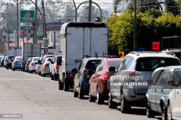 Motorists wait in line to buy gasoline at a Pemex service station in Guadalajara, Jalisco state on January 19, 2019. - Mexican President Andres...