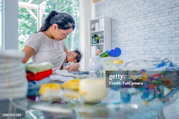 junge mutter stillen während der arbeit - busy mum mess stock-fotos und bilder