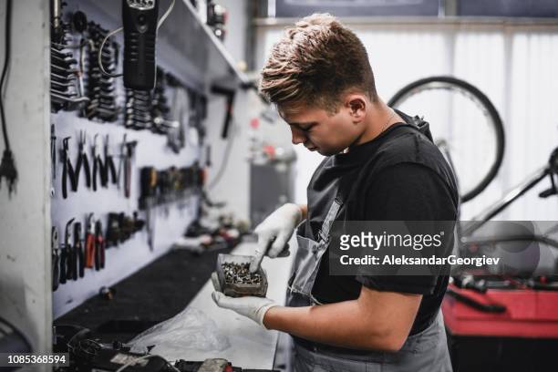 mannelijke mechanic selecteer een rechterdeel - bike mechanic stockfoto's en -beelden