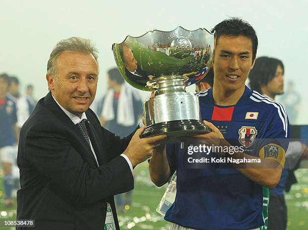 Japanese coach Alberto Zaccheroni and captain Makato Hasebe hold the winners trophy after the AFC Asian Cup Final match between the Australian...