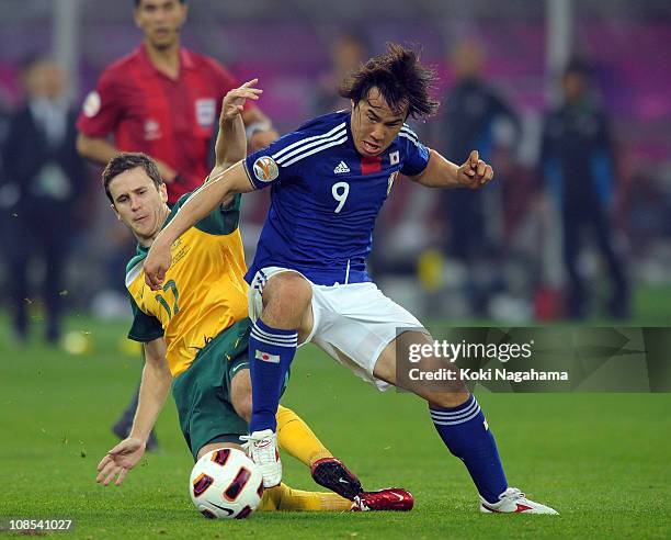 Sjinji Okazaki of Japan and Matt Mckay of Austraria compete for the ballduring the AFC Asian Cup Final match between the Australian Socceroos and...