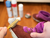 man cleans suede shoe with special brush