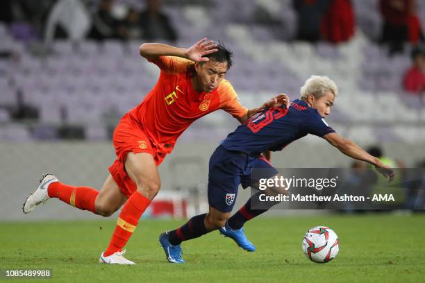 Feng Xiaoting of China tangles with Chanathip Songkrasin of Thailand during the AFC Asian Cup round of 16 match between Thailand and China at Hazza...