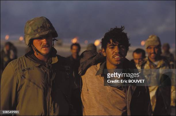 Soldier and Iraqi prisoner in the Kuwaiti desert, Kuwait on February 27th, 1991.
