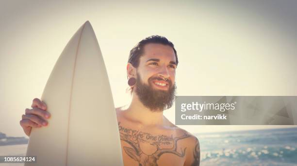 mann mit surfbrett am strand - surfer by the beach australia stock-fotos und bilder