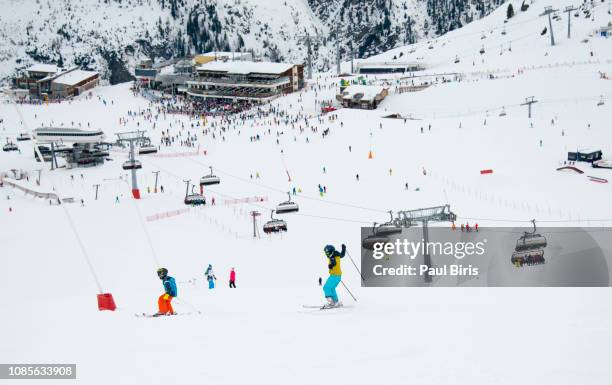 kids practicing skiing on a sunny winter day, the ski resort ischgl silvretta arena, austria - skipiste stockfoto's en -beelden