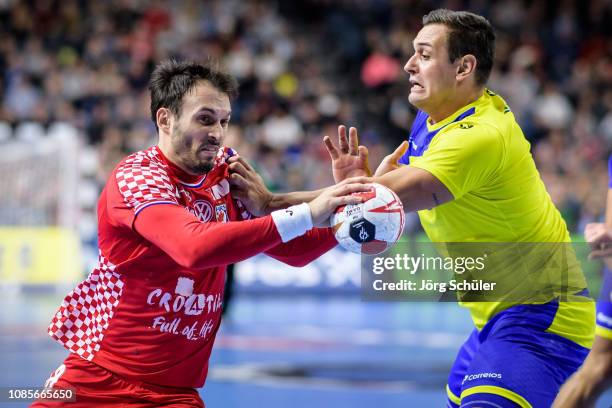 Igor Karacic of Croatia is challenged by Jose Toledo of Brazil during the Main Group 1 match at the 26th IHF Men's World Championship between Brazil...