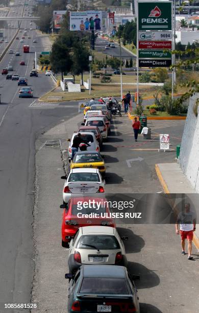 Motorists wait in line to buy gasoline at a Pemex service station in Zapopan, Jalisco state on January 20, 2019. - Mexican President Andres Manuel...