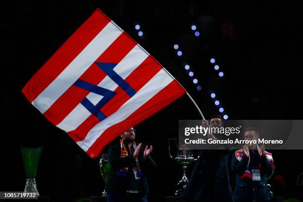 Fromer Atletico de Madrid player Gabi Fernandez waves a flag as he attends a tribute in his honor after the La Liga match between Club Atletico de...