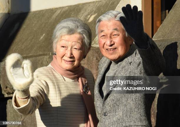 Japan's Emperor Akihito and Empress Michiko wave to well-wishers at the end of their stroll on a beach near the Hayama Imperial Villa in Hayama,...