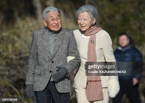 Japan's Emperor Akihito and Empress Michiko stroll on a beach near the Hayama Imperial Villa in Hayama, Kanagawa Prefecture on January 21, 2019....