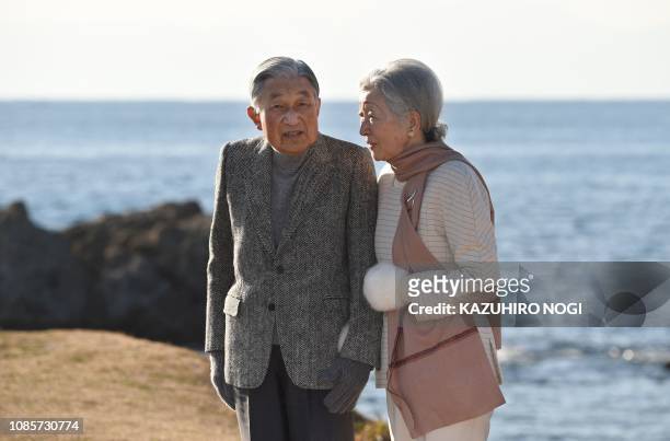 Japan's Emperor Akihito and Empress Michiko stroll on a beach near the Hayama Imperial Villa in Hayama, Kanagawa Prefecture on January 21, 2019....