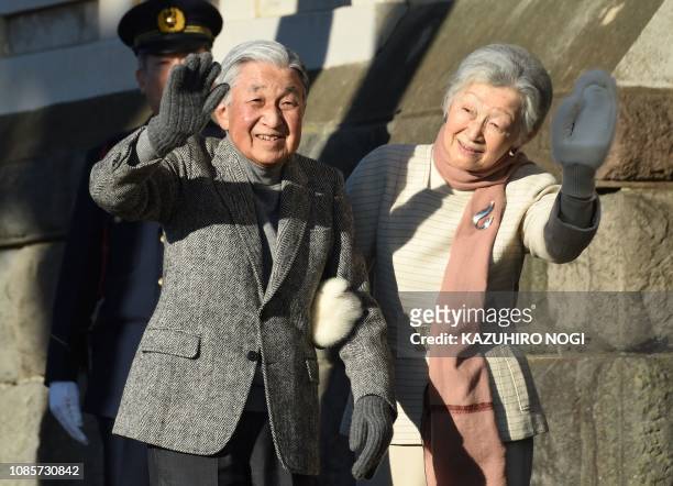 Japan's Emperor Akihito and Empress Michiko wave to well-wishers at the end of their stroll on a beach near the Hayama Imperial Villa in Hayama,...