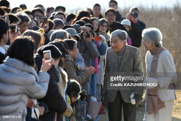 Japan's Emperor Akihito and Empress Michiko meet well-wishers as they stroll on a beach near the Hayama Imperial Villa in Hayama, Kanagawa Prefecture...
