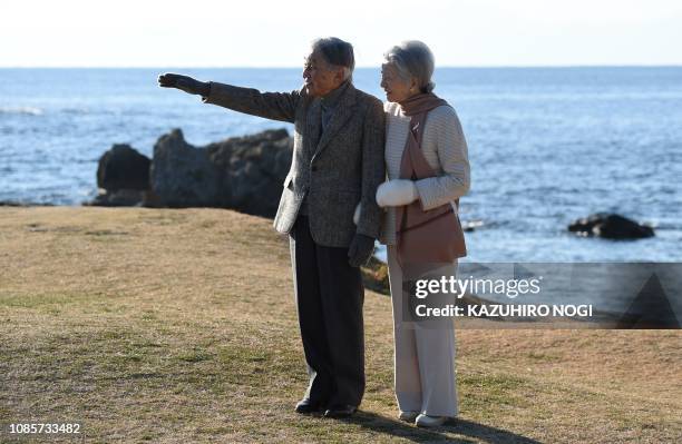 Japan's Emperor Akihito and Empress Michiko stroll on a beach near the Hayama Imperial Villa in Hayama, Kanagawa Prefecture on January 21, 2019....