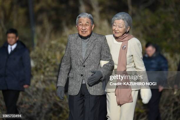 Japan's Emperor Akihito and Empress Michiko stroll on a beach near the Hayama Imperial Villa in Hayama, Kanagawa Prefecture on January 21, 2019....