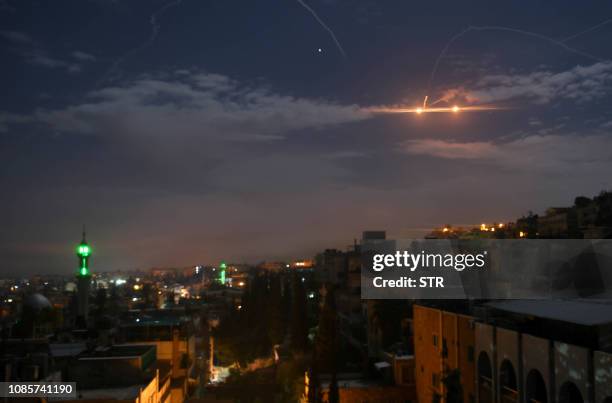 Picture taken early on January 21, 2019 shows Syrian air defence batteries responding to what the Syrian state media said were Israeli missiles...