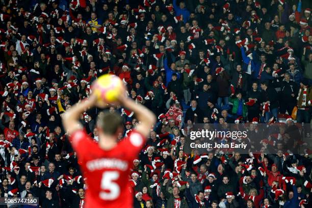 Southampton fans wave their Christmas hats in the air while Jack Stephens of Southampton takes a throw in during the Premier League match between...